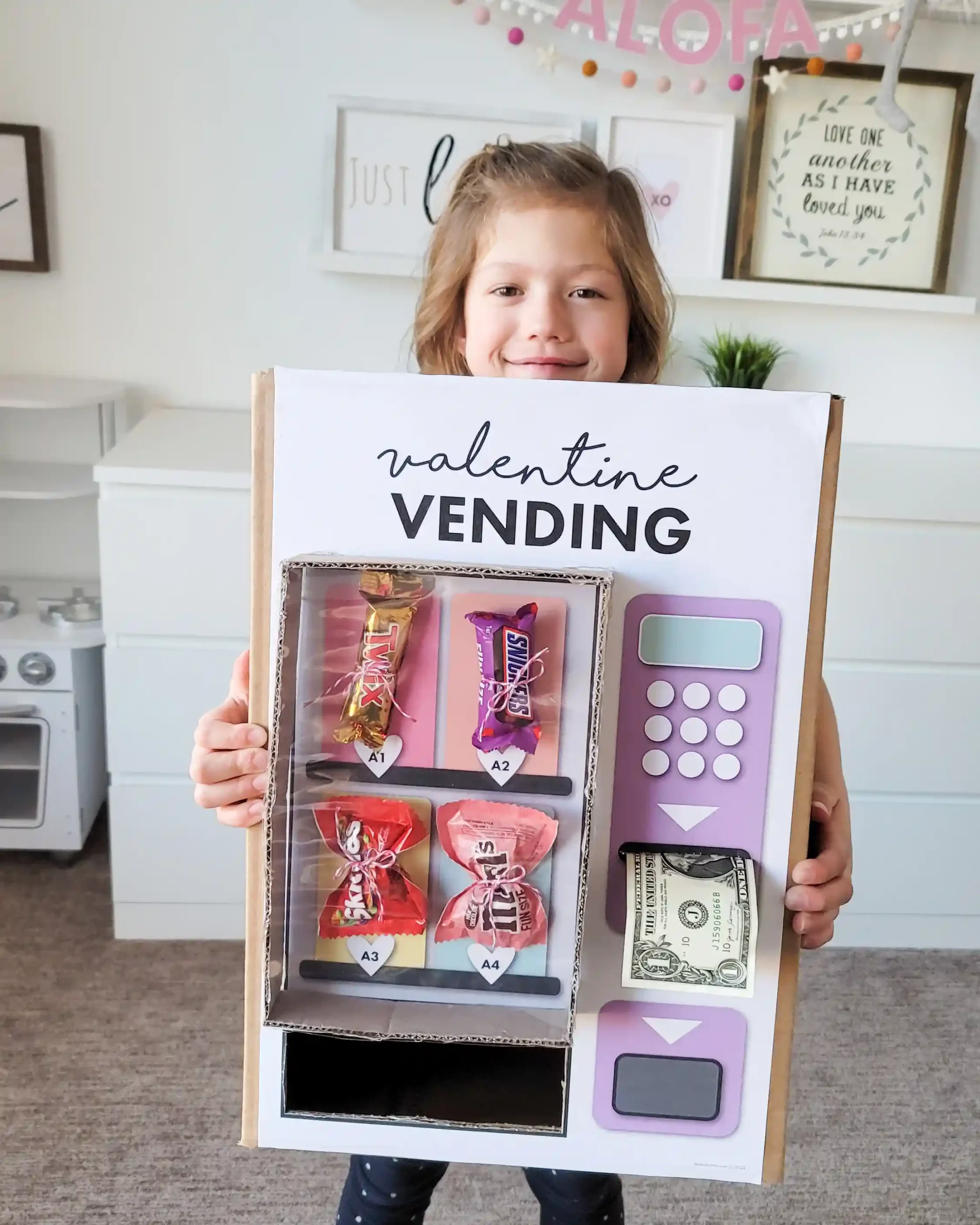 Valentine vending machine DIY Valentine's Day box. The perfect Valentine's Day box to take to school and impress your class. This is a fun and easy project that just requires you to download the Valentine vending machine printable, cut out, and paste to your box. Embellish with your favorite candy and you've got a simple and adorable box to collect your Valentine's Day cards.